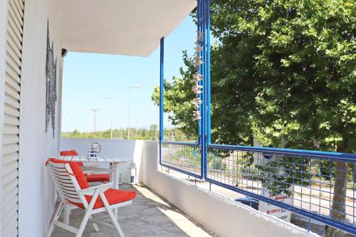 a balcony with a table and chairs and a large window at Gentle Breeze apartment in Kamena Vourla