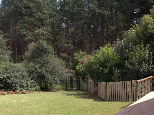 a wooden fence in a yard with trees at Fiddler's Green in Magoebaskloof