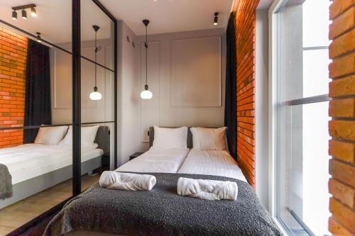 um quarto com uma cama e duas camas. em Red Old Town Apartament em Elblag