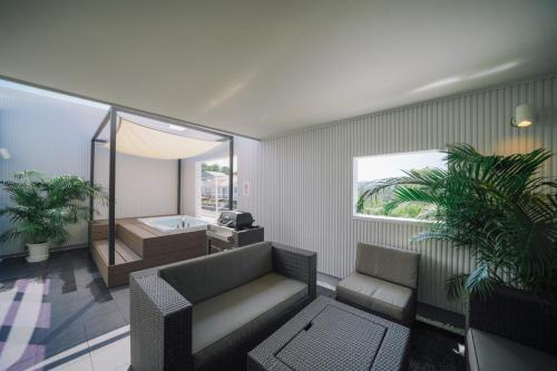 - un salon avec un canapé et une baignoire dans l'établissement Kunigami-gun - House / Vacation STAY 47389, à Onna