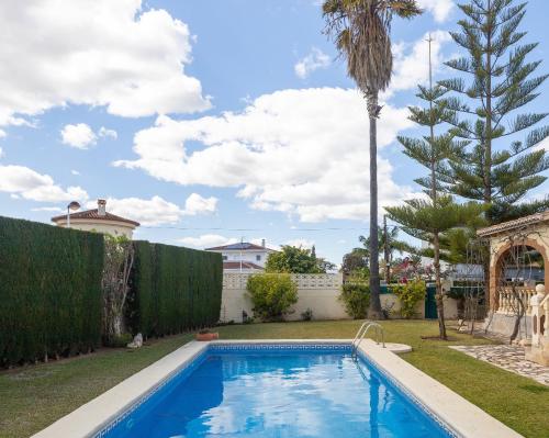 - une piscine dans une cour avec un palmier dans l'établissement Villa Vilches, à Els Poblets