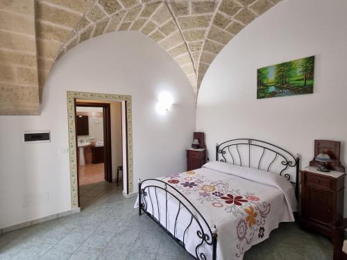 1 dormitorio con 1 cama en una habitación con un arco en Villa Papaleo B&B, en Bagnolo del Salento