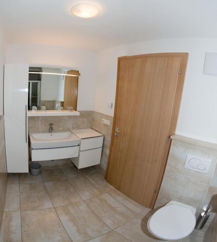 a bathroom with a toilet and a sink at Residence Fiegl in Schenna
