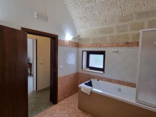 Bagnolo del SalentoにあるVilla Papaleo B&Bのバスルーム(バスタブ付)、窓が備わります。