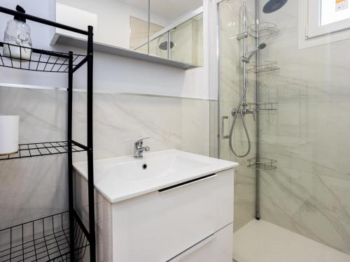 a white bathroom with a sink and a shower at 18 Beautiful Costa Rica Apartment Madrid in Madrid