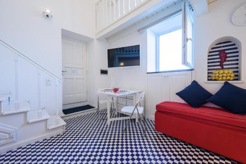 uma sala de estar com um sofá vermelho e uma mesa em A Fenestella Caprese - Sea View em Capri