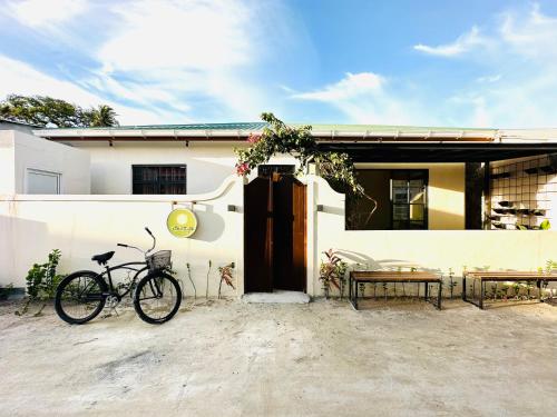 a bike parked in front of a house at The Bilimbi Guesthouse & Inn in Huraa