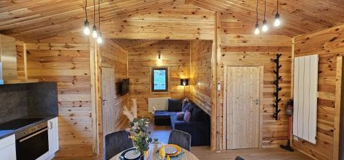 een blokhut met een keuken en een woonkamer bij Chalet Istres des Ardennes in Fromelennes