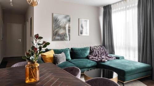 uma sala de estar com um sofá verde e uma mesa em Lion Apartments - SCALA City Center Apartments&Parking IK em Gdansk