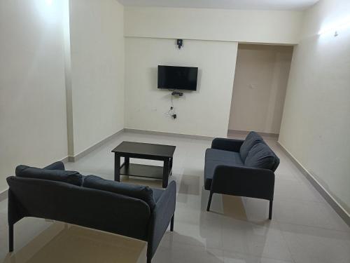 a living room with two couches and a table at Sri Vidya Palace in Udupi
