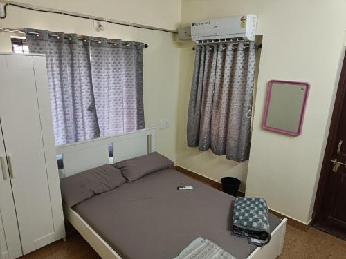 a small room with a bed and a mirror at Sri Vidya Palace in Udupi