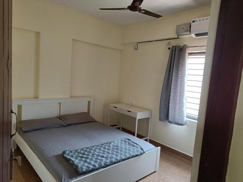 a small bedroom with a bed and a window at Sri Vidya Palace in Udupi