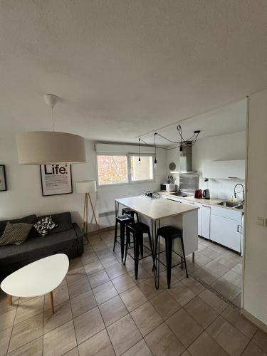een keuken en een woonkamer met een tafel en stoelen bij Charmant F2 Port Marianne (15 Min Plages/Centre-ville) in Montpellier