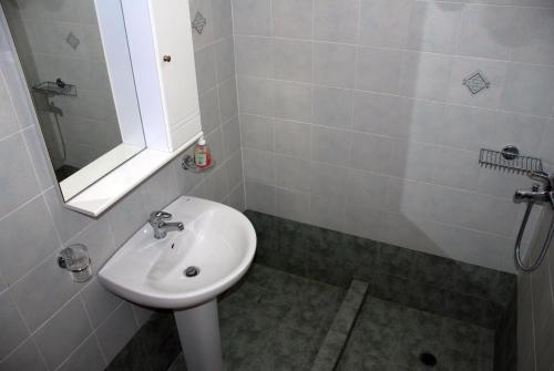 a bathroom with a sink and a mirror at Koulas Pension - Red Lake in Agios Prokopios