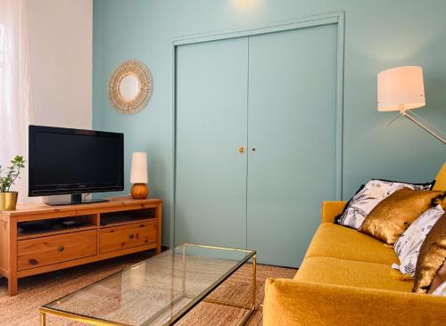 a living room with a couch and a television at Proche Avignon au calme in Les Angles Gard