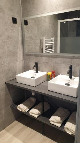 - une salle de bains avec 2 lavabos sur une étagère et des serviettes dans l'établissement BACKSTAGE STUDIO, à Maury
