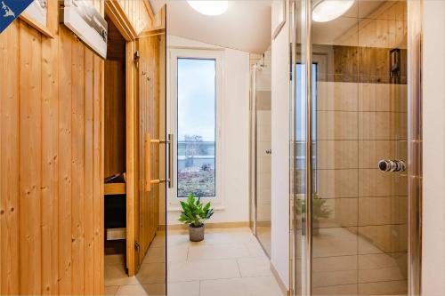 a bathroom with a shower and a glass door at An der Haffküste Haffkoje in Zirchow
