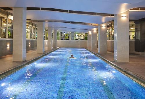 a person swimming in an indoor swimming pool at 4-Bedroom House-Sleeps 15-Central London-Lift and Roof Terrace in London