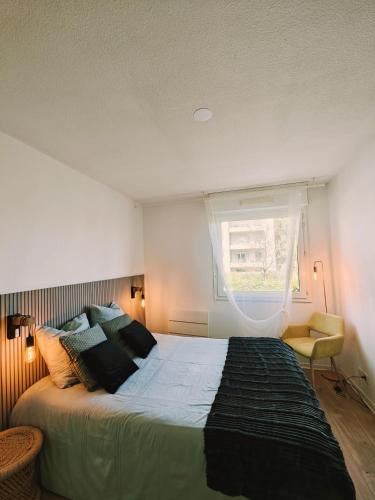 une chambre avec un grand lit et une fenêtre dans l'établissement Direct Aéroport et centre historique de Bordeaux, à Mérignac