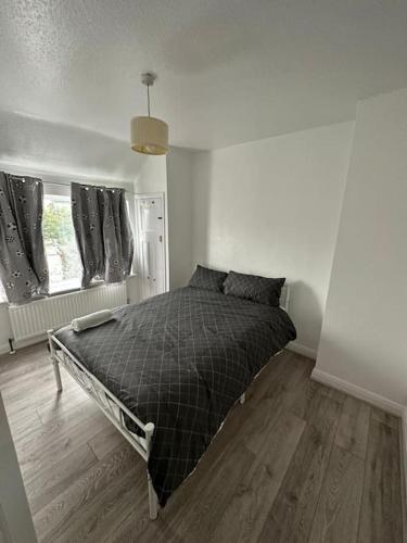 ein Schlafzimmer mit einem Bett in einem weißen Zimmer in der Unterkunft 30 min STN or to central London in Enfield Lock