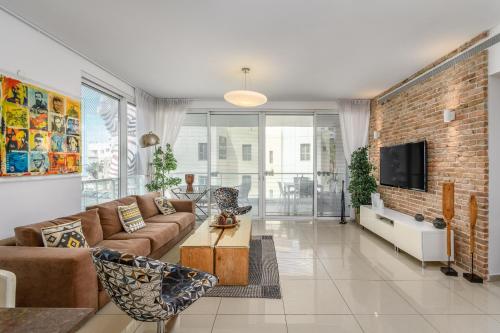 - un salon avec un canapé et un mur en briques dans l'établissement #Stunning 3BR/2BA Apt - Sea View, à Tel Aviv