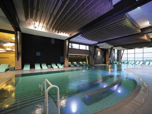 una gran piscina en un hotel con sillas en Maison calme et lumineuse de plain-pied en Cabourg