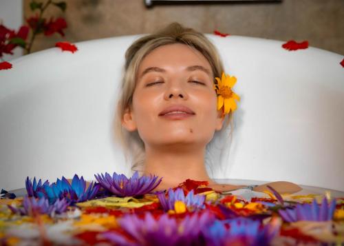 a woman laying in a bed with a flower on her head at AIDA Hotel - Bentota in Bentota