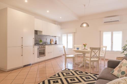 a kitchen and dining room with white cabinets and a table at Palazzo Spada - Appartamento Cigno con 2 camere da letto in Codigoro