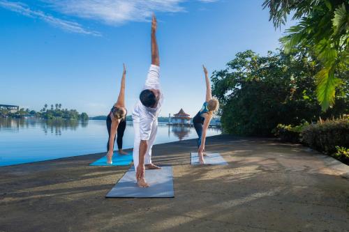 a group of people doing yoga by the water at AIDA Hotel - Bentota in Bentota
