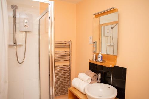 a bathroom with a sink and a shower at Y Cartws Llanwenog in Llanwenog