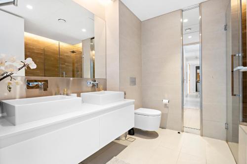 a bathroom with two sinks and a toilet at New 2 bedroom in Bluewaters with Direct Sea View in Dubai