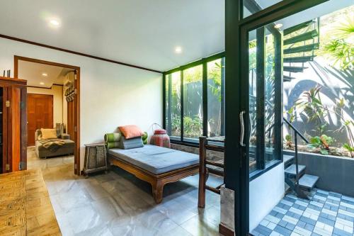 sala de estar con banco y ventanas en Casa Asiatique — 5BR Villa in Laguna & Layan Beach, en Phuket