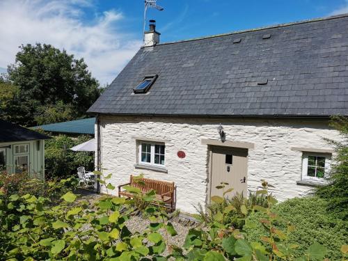a white stone house with a black roof at Blaenfforest Granary Newcastle Emlyn in Capel-Ifan
