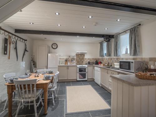a large kitchen with a table and chairs in it at Blaenfforest Granary Newcastle Emlyn in Capel-Ifan