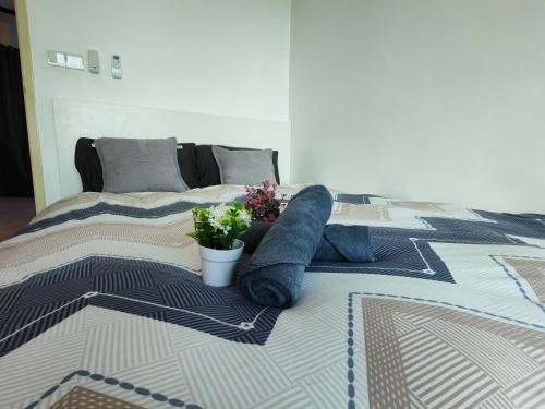 a bed with two pillows and a plant on it at Modern Comfy Suite Room-9Pax in Perai