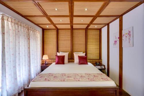 a bedroom with a large bed with red pillows at AIDA Hotel - Bentota in Bentota
