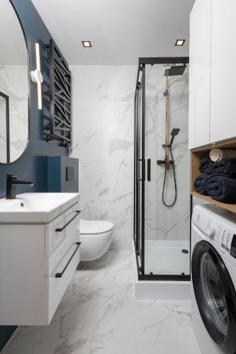 a bathroom with a shower and a washing machine at "Lux Apartament" w pobliżu basen,galeria,siłownia,lotnisko 8min in Radom