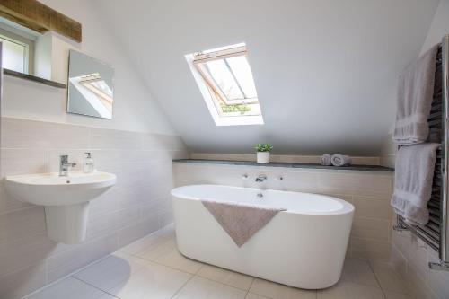 a white bathroom with a sink and a bath tub at Y Cartws Eglwyswrw in Eglwyswrw