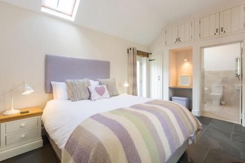 a bedroom with a large bed and a bathroom at Y Cartws Eglwyswrw in Eglwyswrw