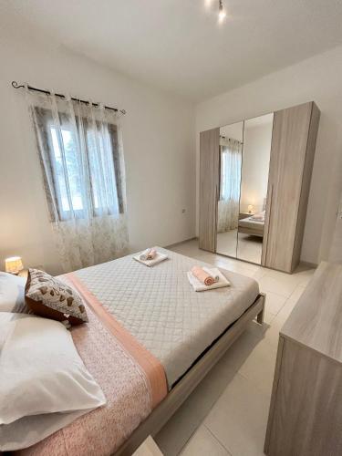 1 dormitorio con cama y espejo grande en La Casetta tra Alghero e Stintino, en Palmadula