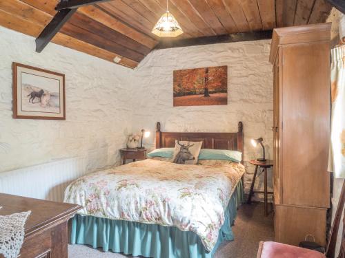 a bedroom with a bed and a wooden ceiling at Rhyd y Brown Cottage Llys Y Fran in Pen-ffordd
