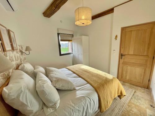 - une chambre avec un grand lit et des oreillers blancs dans l'établissement Maison Melrose Lovely house near Deauville, à Cricquebœuf