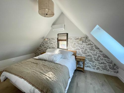 um quarto com uma cama num sótão em Maison Longere Beautiful House near Deauville em Cricquebœuf
