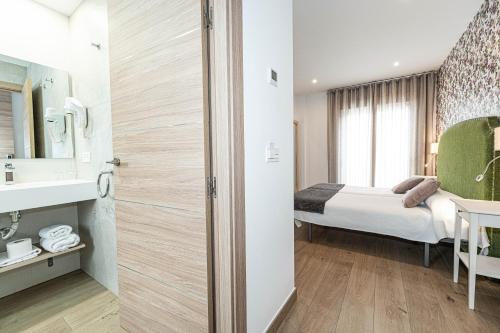 a hotel room with a bed and a bathroom at Hostal Boutique Aurora in Nerja
