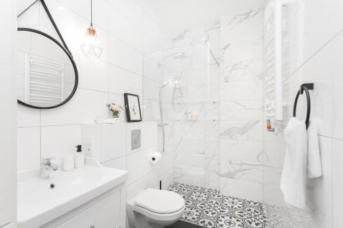 a white bathroom with a shower and a toilet at Radziwiłłowska Old Town Apartments in Krakow