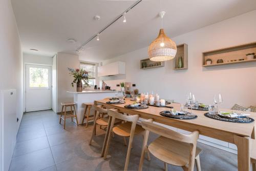 une cuisine et une salle à manger avec une grande table et des chaises en bois dans l'établissement House at ranch between Bruges and Damme, à Bruges