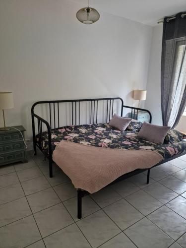1 dormitorio con 1 cama con manta y almohadas en ALOES en Bastia