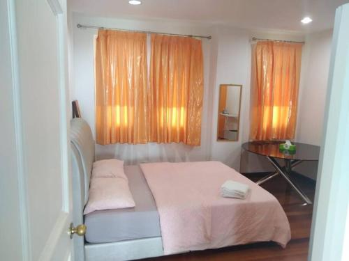 a bedroom with a bed and a window with orange curtains at Duplex Condominium In Bukit Bintang For Rent in Kuala Lumpur