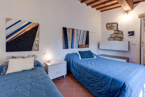 two beds in a bedroom with blue comforter at Antica Dimora di Laura in Barberino di Mugello