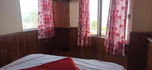 1 dormitorio con 1 cama y 2 ventanas en FLGHR Santhosh Cottage, en Kodaikanal